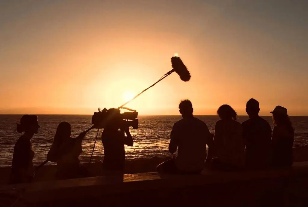 ENG Team and Kameramann filming at sunset by the sea during professional videoproduktion project.