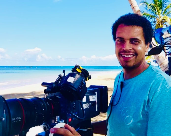 Director of Photography (DoP) with camera at beach filming with professional camera crew – black@white media Munich Germany